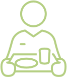 Green outline icon of a person sitting at a table with a plate and cup, symbolizing assisted living services